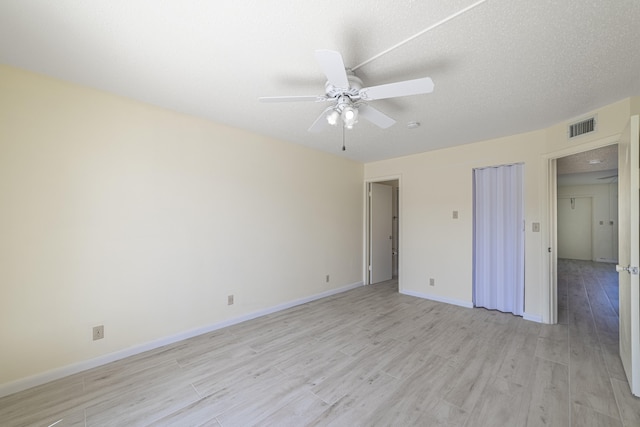 unfurnished bedroom with ceiling fan, light wood-type flooring, and a textured ceiling