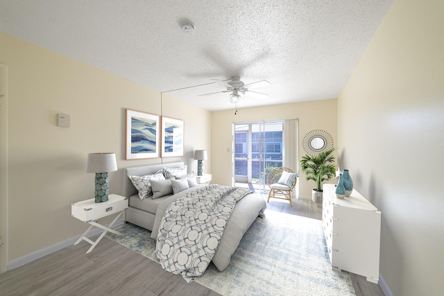 bedroom featuring ceiling fan, a textured ceiling, and light hardwood / wood-style flooring