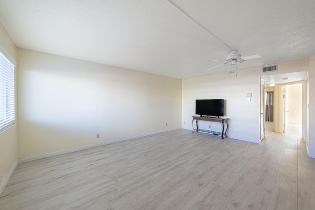 unfurnished living room featuring ceiling fan, light hardwood / wood-style floors, and a textured ceiling