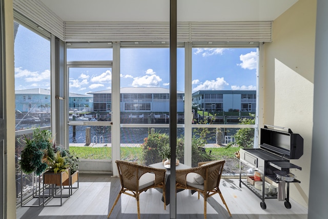 sunroom / solarium featuring a water view