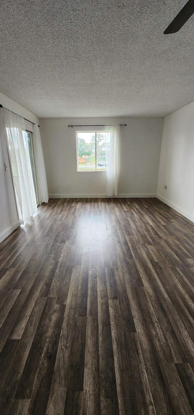 spare room featuring ceiling fan, a textured ceiling, and dark hardwood / wood-style flooring