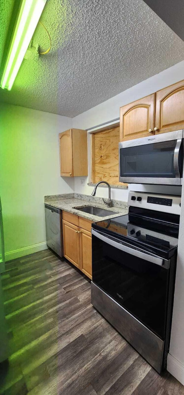 kitchen with appliances with stainless steel finishes, light brown cabinets, sink, and dark hardwood / wood-style flooring