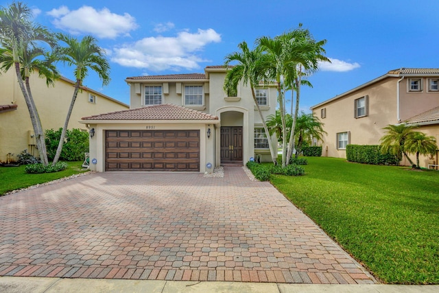 8951 Alexandra Cir, Wellington, FL 33414 - mediterranean / spanish home with stucco siding, a garage, a tile roof, decorative driveway, and a front lawn