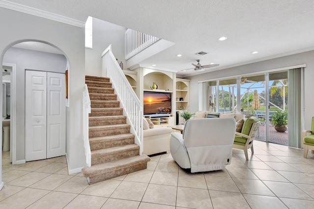 living room featuring crown molding, a textured ceiling, and light tile patterned floors