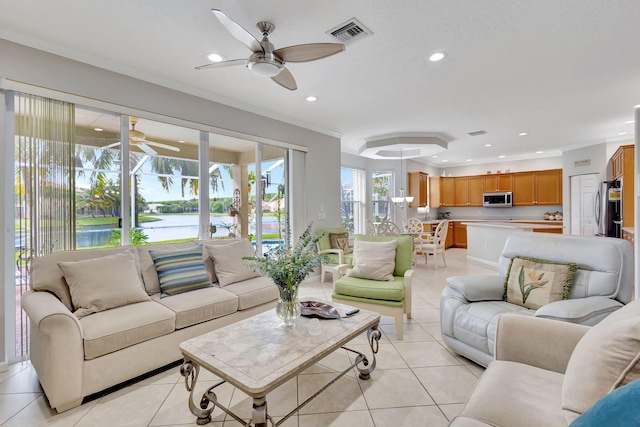 tiled living room featuring crown molding, a water view, and ceiling fan