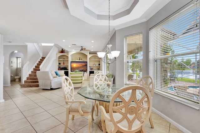 dining space featuring light tile patterned floors, crown molding, a wealth of natural light, and a chandelier