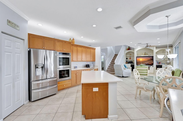 kitchen featuring stainless steel appliances, crown molding, light tile patterned flooring, a center island, and pendant lighting