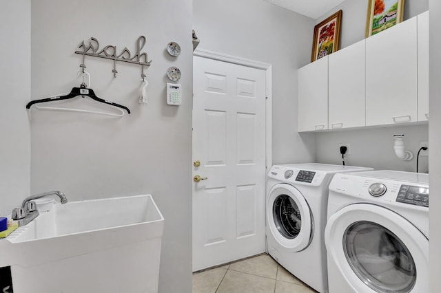 washroom with cabinets, sink, separate washer and dryer, and light tile patterned floors