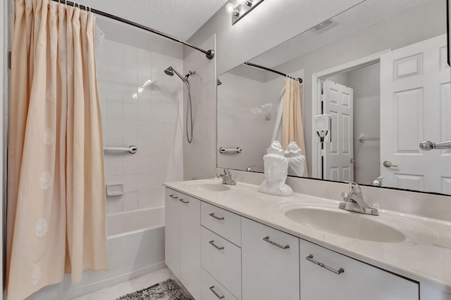 bathroom with vanity, a textured ceiling, shower / bathtub combination with curtain, and tile patterned flooring