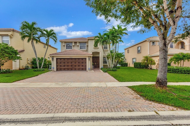 mediterranean / spanish-style house featuring a front yard and a garage