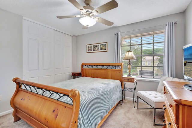 carpeted bedroom featuring a closet and ceiling fan