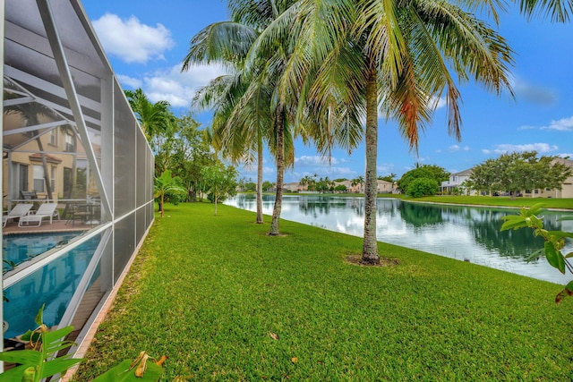 view of yard featuring a patio area, a water view, and a lanai