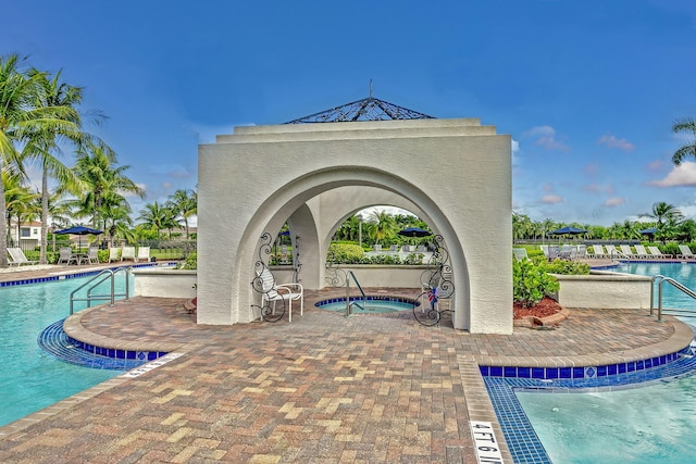 view of swimming pool with a hot tub and a patio area