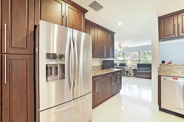 kitchen featuring stainless steel appliances, ceiling fan, light tile patterned floors, and light stone counters