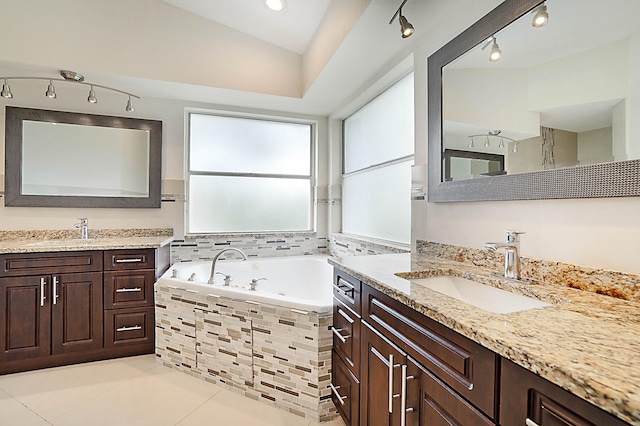 bathroom with vanity, tiled tub, tile patterned floors, and vaulted ceiling