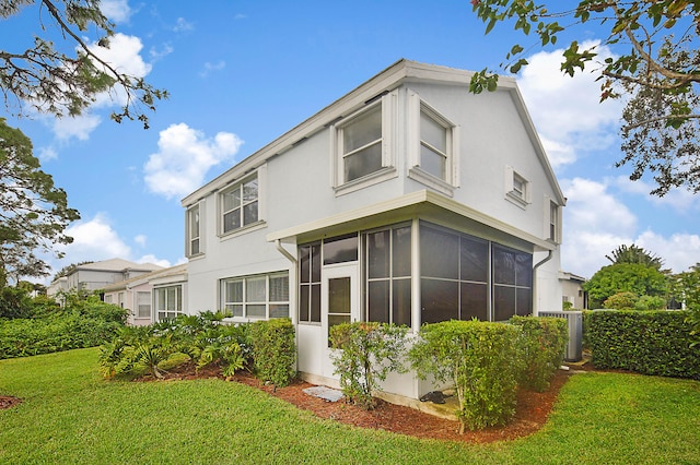 rear view of property with a sunroom and a yard