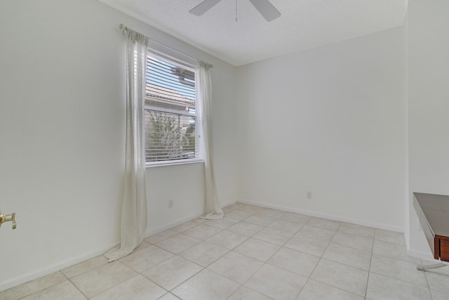 tiled empty room featuring a textured ceiling and ceiling fan