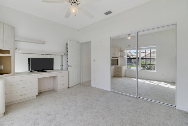 unfurnished bedroom with light carpet, a closet, and ceiling fan