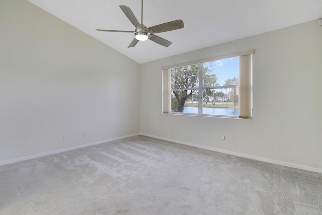 carpeted empty room featuring a water view, lofted ceiling, and ceiling fan