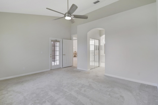 carpeted empty room with ceiling fan and a high ceiling