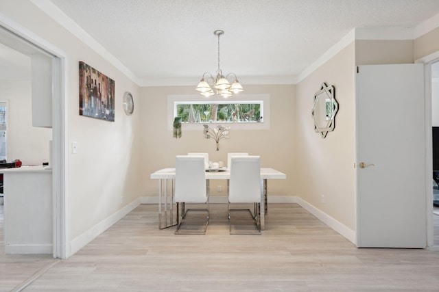 dining space featuring an inviting chandelier, crown molding, a textured ceiling, and light hardwood / wood-style floors