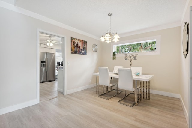 unfurnished dining area featuring crown molding, a textured ceiling, light wood-type flooring, and ceiling fan with notable chandelier