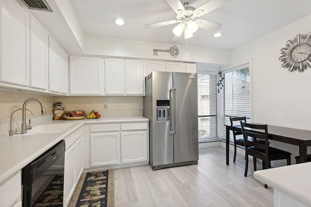 kitchen with high end fridge, black dishwasher, sink, white cabinets, and light hardwood / wood-style floors