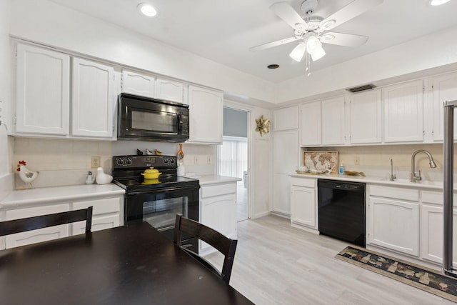 kitchen featuring black appliances, sink, backsplash, white cabinets, and light hardwood / wood-style flooring