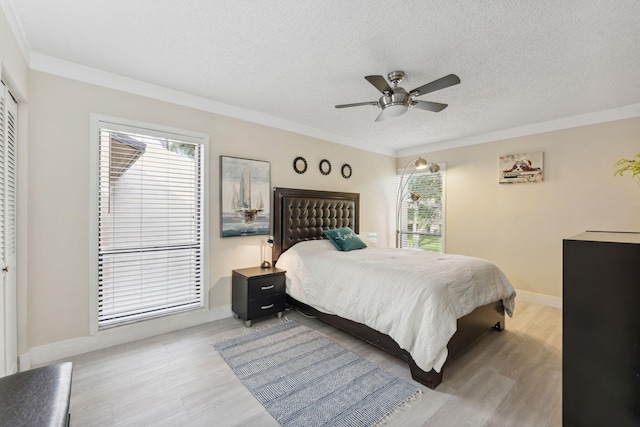 bedroom featuring a closet, a textured ceiling, light wood-type flooring, and ceiling fan