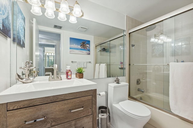 full bathroom with vanity, toilet, and combined bath / shower with glass door