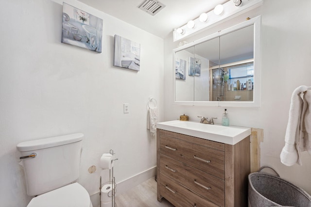 bathroom featuring vanity, toilet, hardwood / wood-style flooring, and an enclosed shower