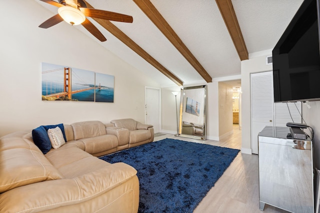 living room featuring light hardwood / wood-style flooring, vaulted ceiling with beams, and ceiling fan