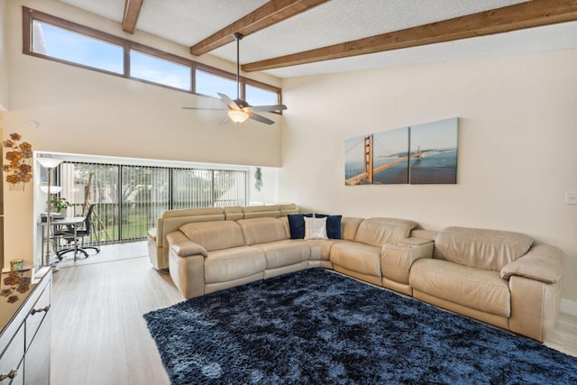 living room with light hardwood / wood-style floors, beam ceiling, high vaulted ceiling, and ceiling fan