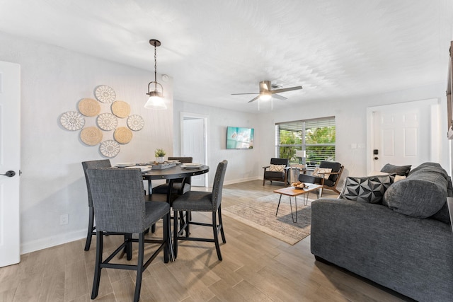 dining space with light hardwood / wood-style floors and ceiling fan