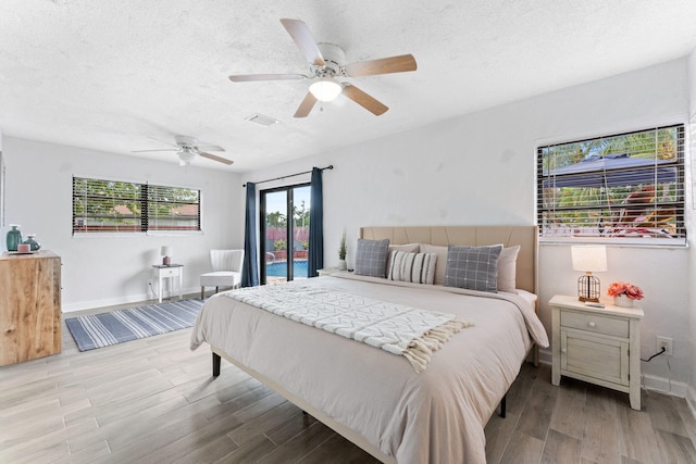 bedroom with multiple windows, light hardwood / wood-style floors, and ceiling fan