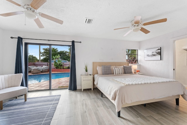 bedroom with access to outside, a textured ceiling, light wood-type flooring, and ceiling fan