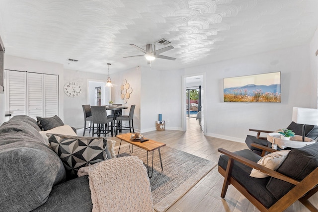 living room featuring light wood-type flooring and ceiling fan