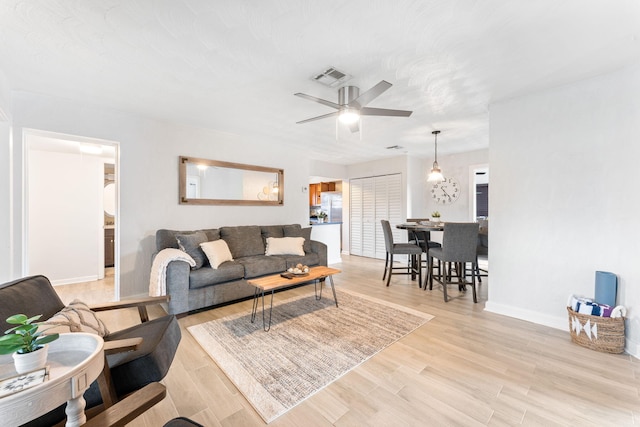 living room with ceiling fan and light wood-type flooring