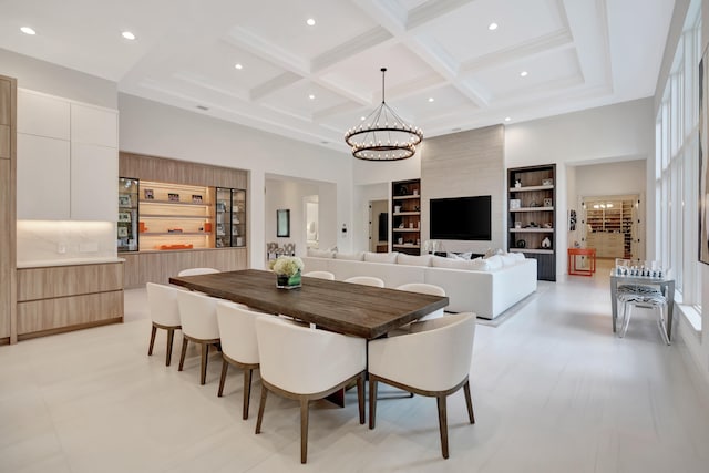 dining room with an inviting chandelier, beamed ceiling, a high ceiling, built in features, and coffered ceiling