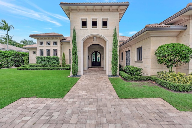 view of exterior entry featuring a yard