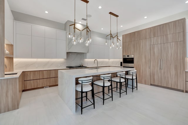 kitchen featuring a spacious island, white cabinetry, stainless steel appliances, decorative light fixtures, and decorative backsplash