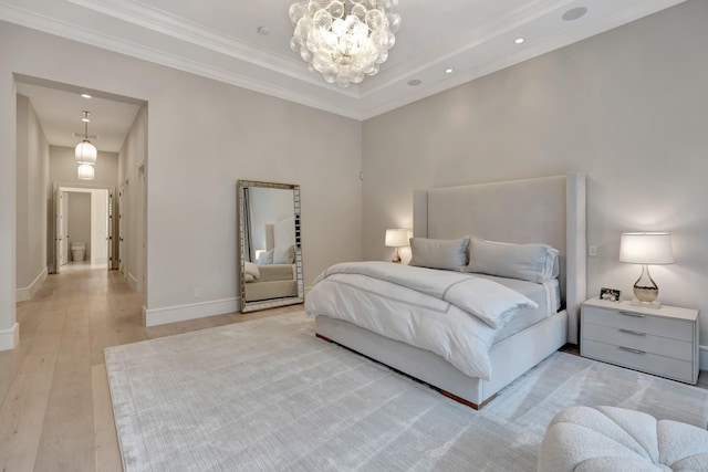 bedroom featuring a towering ceiling, a notable chandelier, ornamental molding, and light wood-type flooring