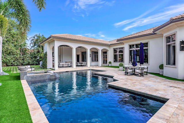 view of swimming pool with a patio, an in ground hot tub, and a lawn