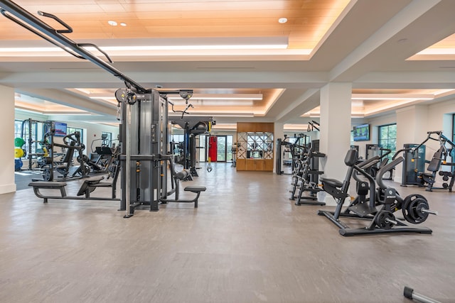 workout area with a tray ceiling