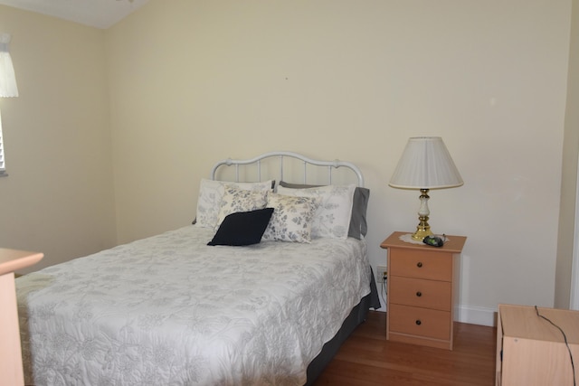 bedroom with dark wood-type flooring