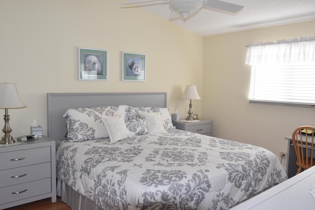 bedroom featuring dark wood-type flooring, a textured ceiling, and ceiling fan