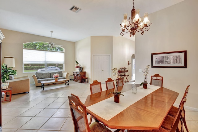 dining space with light tile patterned flooring and ceiling fan with notable chandelier