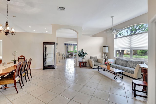 living room with ceiling fan with notable chandelier and light tile patterned floors