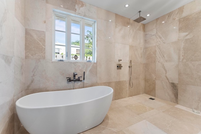 bathroom featuring plus walk in shower and tile walls