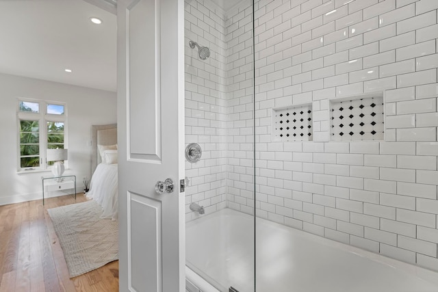 bathroom featuring tiled shower / bath and hardwood / wood-style flooring